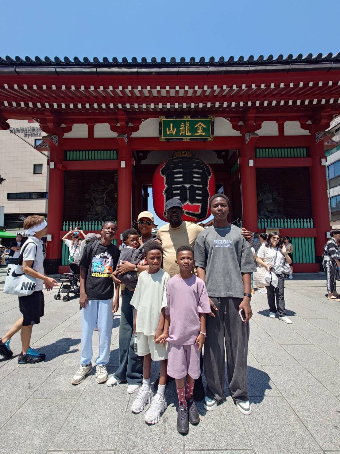 A family of eight in front of the Kaminarimon gate at Senso-ji temple in Asakusa, Tokyo